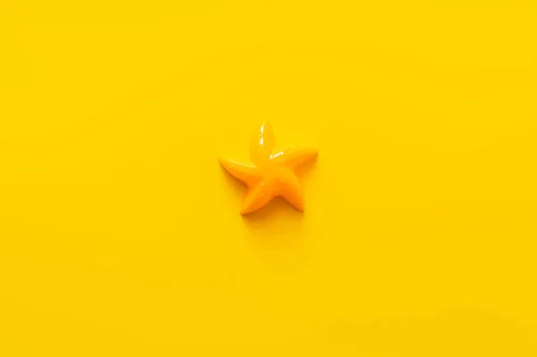 Top view of plastic starfish mold on bright yellow background — Stock Photo