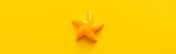 Top view of bright starfish toy on yellow background, banner — Stock Photo