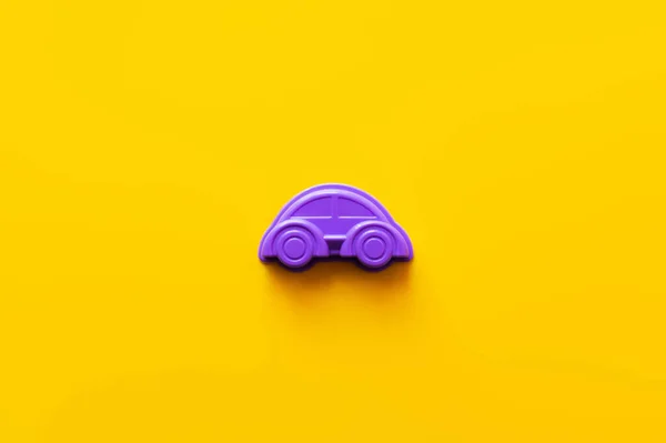 Vue de dessus de la voiture en plastique violet sur fond jaune vif — Photo de stock