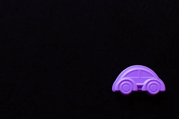 Vue de dessus de voiture jouet violet vif isolé sur noir avec espace de copie — Photo de stock