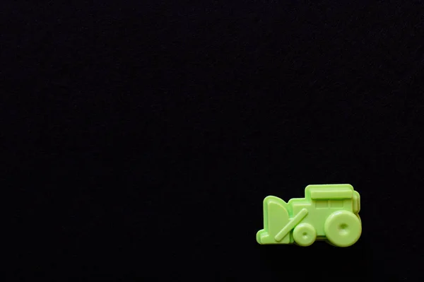 Vista superior de la excavadora de juguete verde aislada en negro con espacio de copia - foto de stock