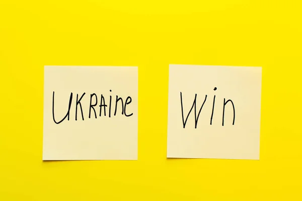 Top view of paper cards with ukraine win lettering yellow background — Stock Photo