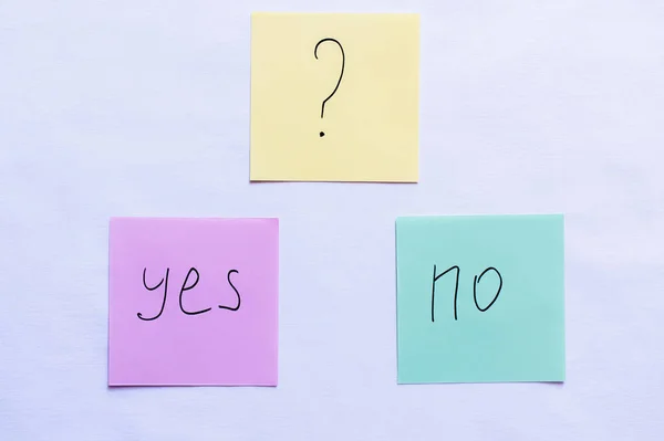 Top view of cards with question mark above yes and no words on white background — Stock Photo