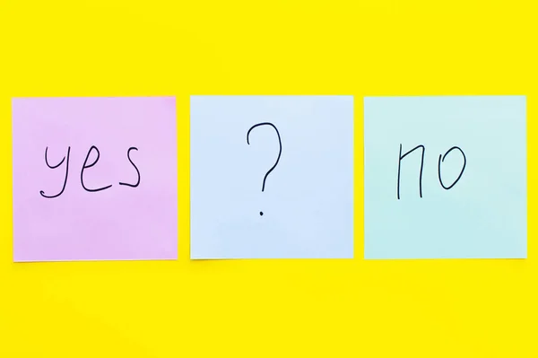 Top view of sticky notes with question mark between yes and no words on bright yellow background — Stock Photo