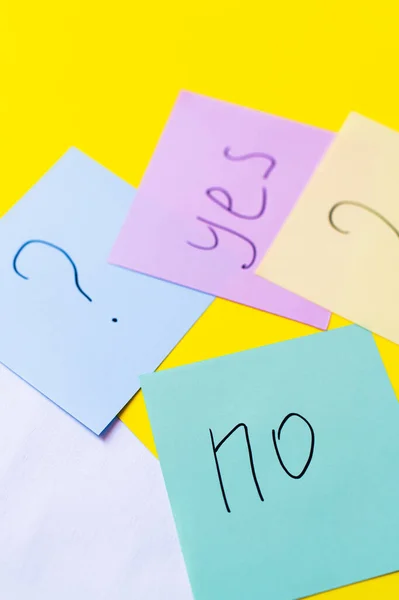 Top view of paper notes with question mark near yes and no lettering on yellow background — Stock Photo