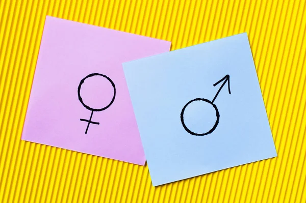 Top view of violet cards with gender identity symbols on yellow textured background — Stock Photo