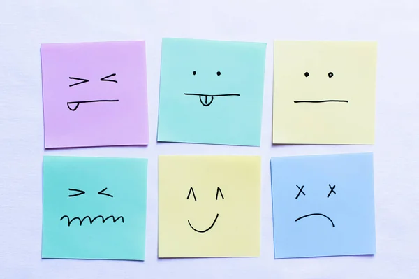 Vista superior de tarjetas de papel con varios emoticonos sobre fondo blanco - foto de stock