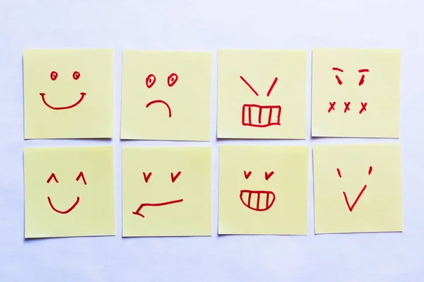 Top view of sticky notes with positive and negative smileys on white background — Stock Photo