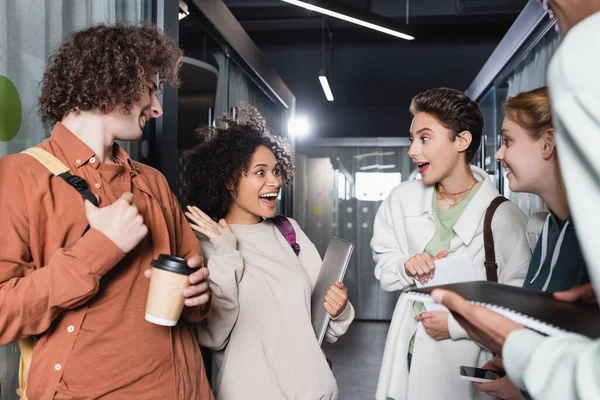 Amazed african american woman showing wow gesture near interracial classmates — Stock Photo