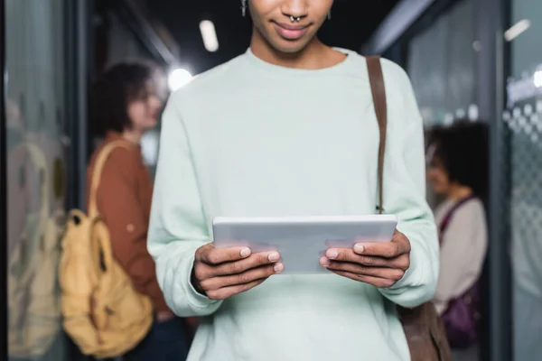 Ausgeschnittene Ansicht eines afrikanisch-amerikanischen Studenten mit digitalem Tablet auf verschwommenem Hintergrund — Stockfoto