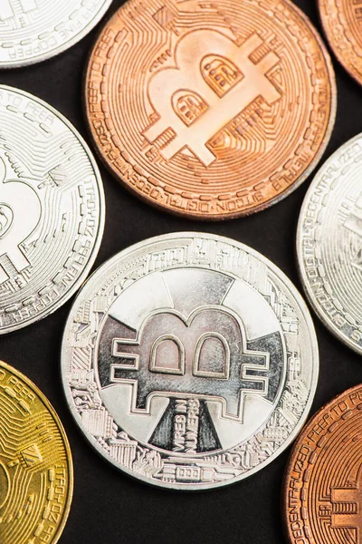 KYIV, UKRAINE - APRIL 26, 2022: Top view of various bitcoin on black background — стокове фото