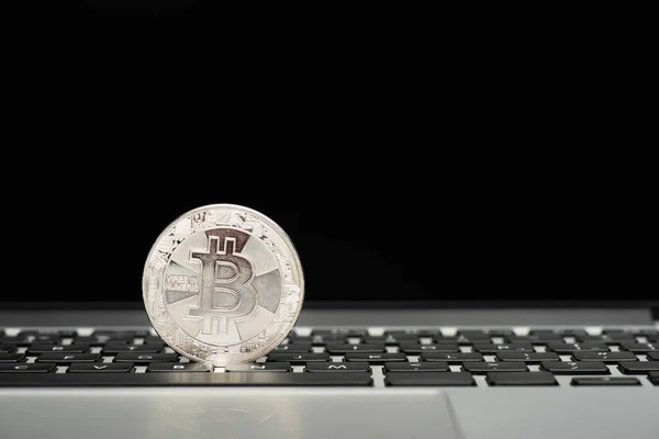 KYIV, UKRAINE - APRIL 26, 2022: Close up view of silver bitcoin on laptop keyboard on black background — Stock Photo