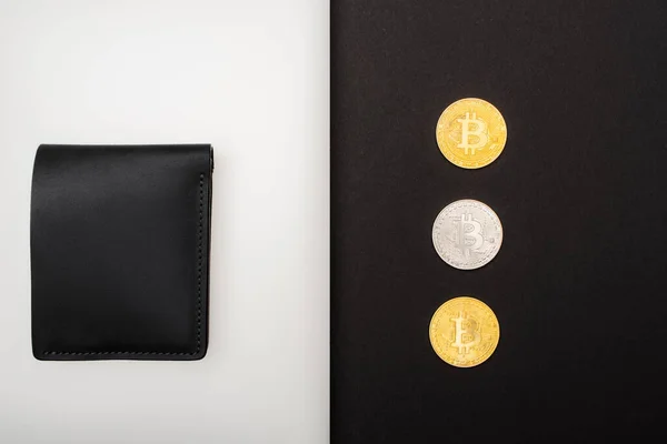 KIEW, UKRAINE - 26. April 2022: Ansicht von Bitcoins in der Nähe der Brieftasche auf Laptop auf schwarzem Hintergrund — Stockfoto