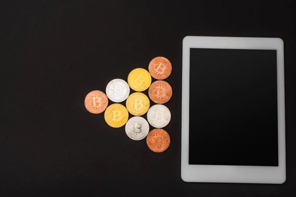 KYIV, UKRAINE - APRIL 26, 2022: Top view of crypto coins near digital tablet isolated on black — Stock Photo