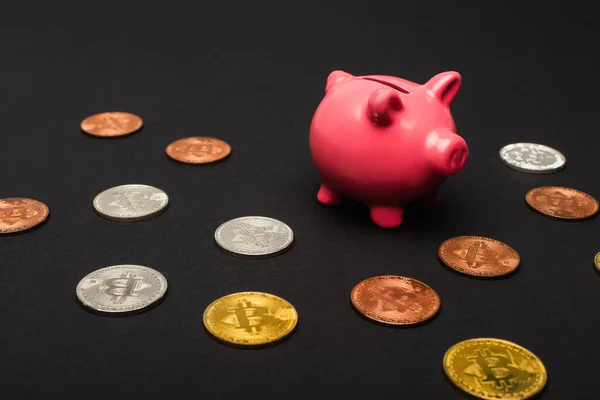 KYIV, UKRAINE - APRIL 26, 2022: Different crypto coins near piggy bank on black background — Stock Photo