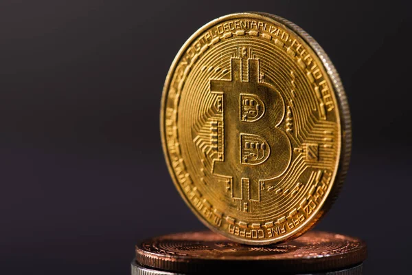 KYIV, UKRAINE - APRIL 26, 2022: Close up view of golden bitcoin on crypto coins isolated on black — Stock Photo