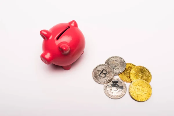 KYIV, UKRAINE - APRIL 26, 2022: High angle view of piggy bank and cryptocurrency on white background — Stock Photo