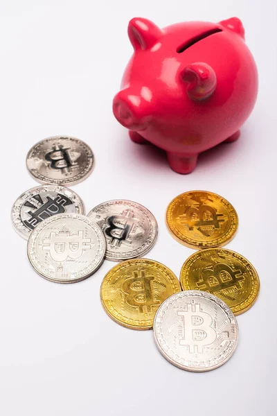 KYIV, UKRAINE - APRIL 26, 2022: Close up view of bitcoins and piggy bank on white background — Stock Photo