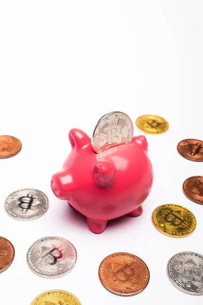 KYIV, UKRAINE - APRIL 26, 2022: Cryptocurrency near pink piggy bank on white background — Stock Photo