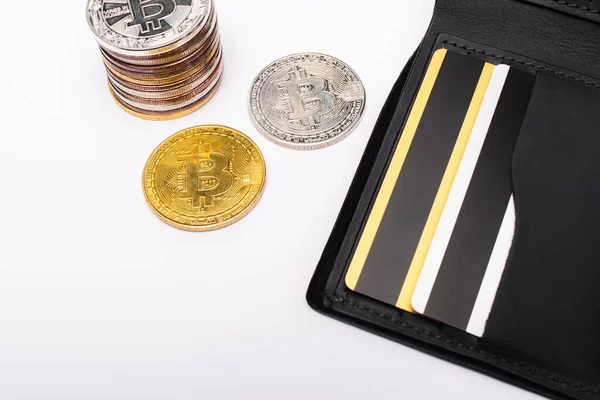 KYIV, UKRAINE - APRIL 26, 2022: Top view of wallet with credit cards and bitcoins on white background — Stock Photo