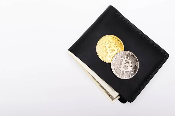 QUIIV, UCRÂNIA - 26 de abril de 2022: Vista superior de moedas criptografadas na carteira com dólares isolados em branco — Fotografia de Stock