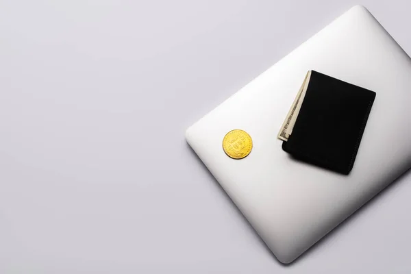 KYIV, UKRAINE - APRIL 26, 2022: Top view of bitcoin and wallet on laptop on grey background — Stock Photo