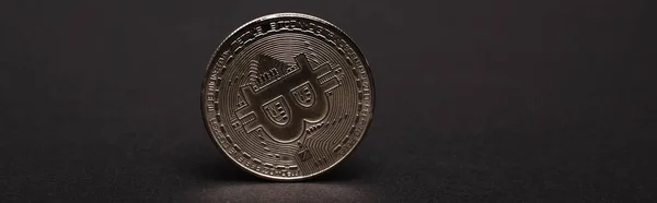 KYIV, UKRAINE - APRIL 26, 2022: Close up view of silver bitcoin on black background, banner — Stock Photo