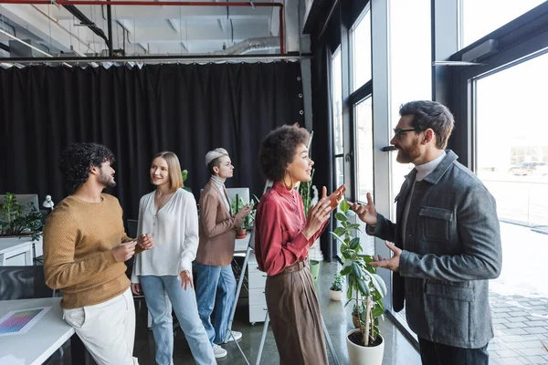 Multiethnische Werbeagenten gestikulieren während eines Gesprächs im Büro — Stockfoto