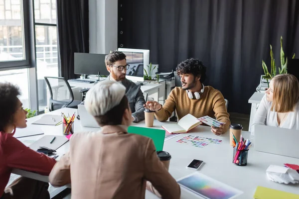 Indiana publicidade designer segurando amostras de cor durante reunião com colegas inter-raciais — Fotografia de Stock