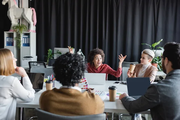 Étonné femme afro-américaine montrant wow geste près de collègues multiethniques dans l'agence de publicité — Photo de stock