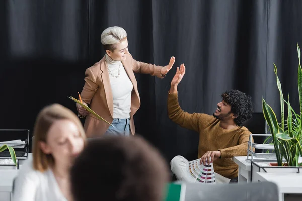 Indischer Mann gibt in Werbeagentur High Five an glückliche Frau — Stockfoto