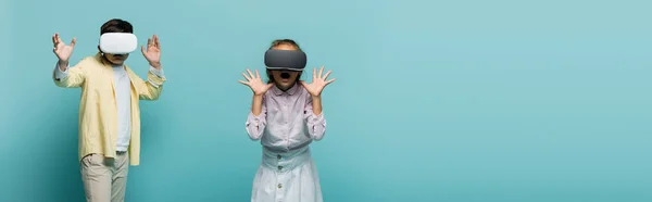 Afraid kids in virtual reality headsets on blue background, banner — Stock Photo