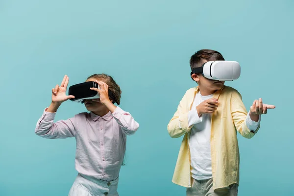 Preteen Kinder in vr Headsets spielen Videospiel und gestikulieren isoliert auf blau — Stockfoto