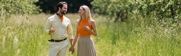 Trendy couple holding hands and talking in summer park, banner — Stock Photo