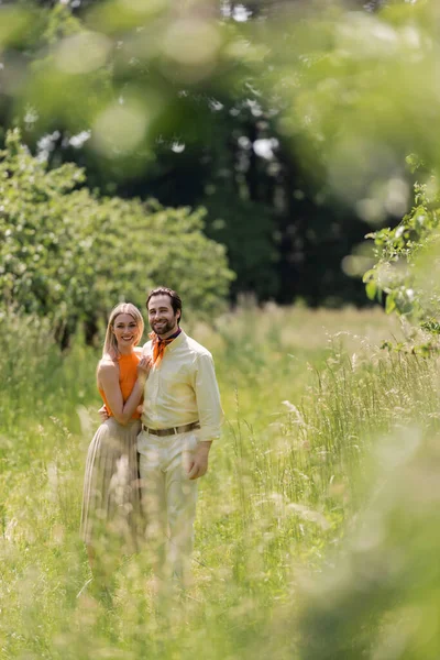 Casal elegante abraçando e olhando para a câmera no parque de verão — Fotografia de Stock