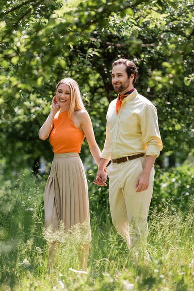 Couple élégant positif marchant dans le parc d'été — Photo de stock