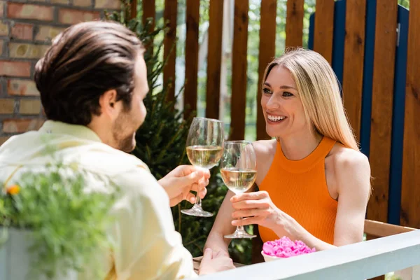 Romántica pareja de tostadas con vino en la cafetería al aire libre - foto de stock