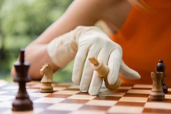 Ausgeschnittene Ansicht einer Frau im Handschuh, die im Park Schach spielt — Stockfoto