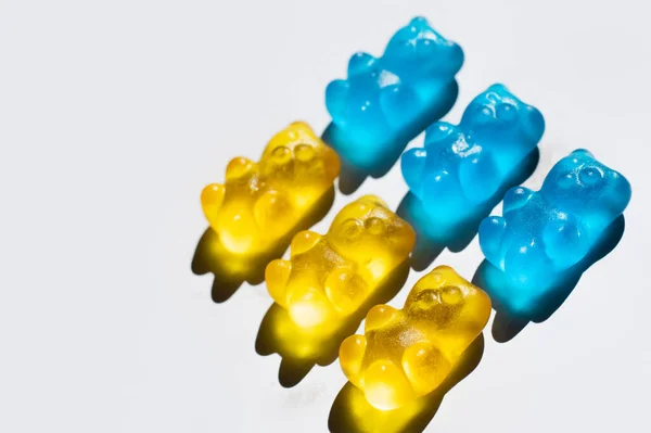 Vue grand angle des ours en gomme jaune et bleue sur fond blanc — Photo de stock