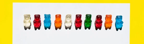 Top view of line from jelly bears on white and yellow, banner — Stock Photo