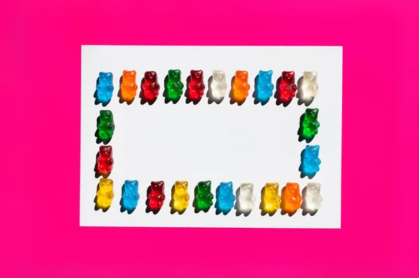 Flache Liege mit bunten Gummibärchen auf weißer und pinkfarbener Oberfläche — Stockfoto