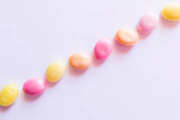 Posa piatta con caramelle colorate su sfondo bianco — Foto stock
