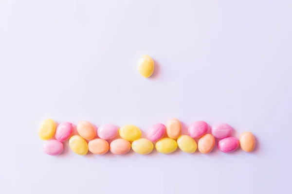 Vista superior de doces perto de doces coloridos no fundo branco — Fotografia de Stock