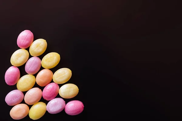 Flat lay with colorful candies isolated on black — Stock Photo