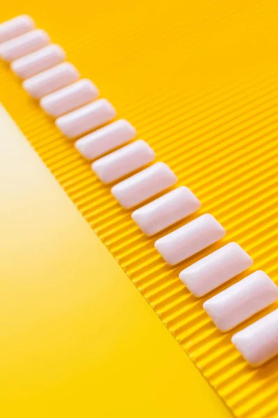 Flat lay from white chewing gums on yellow background with copy space — Stock Photo