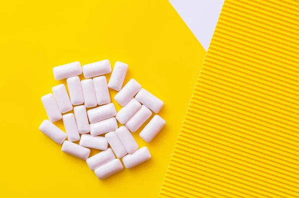 Top view of white chewing gums on yellow background — Stock Photo