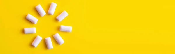 Vue du dessus de la forme ronde de gommes à mâcher blanches sur fond jaune, bannière — Photo de stock