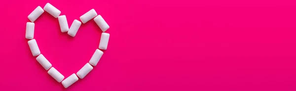 Top view of heart symbol from chewing gums on pink background, banner — Stock Photo