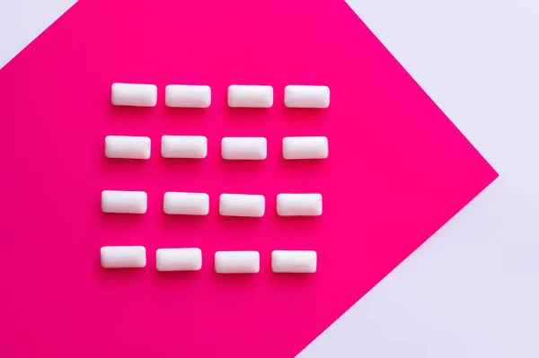 Posa piatta con gengive da masticare su sfondo rosa e bianco — Foto stock