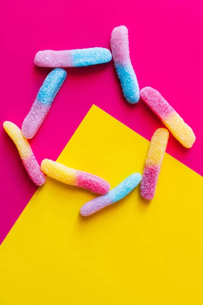 Flat lay with delicious jelly sweets on pink and yellow background — Stock Photo